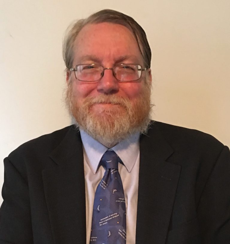 Man with glasses wearing tie and jacket