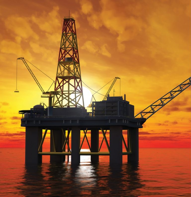 Oil rig silhouetted against a vibrant orange sunset over calm waters.