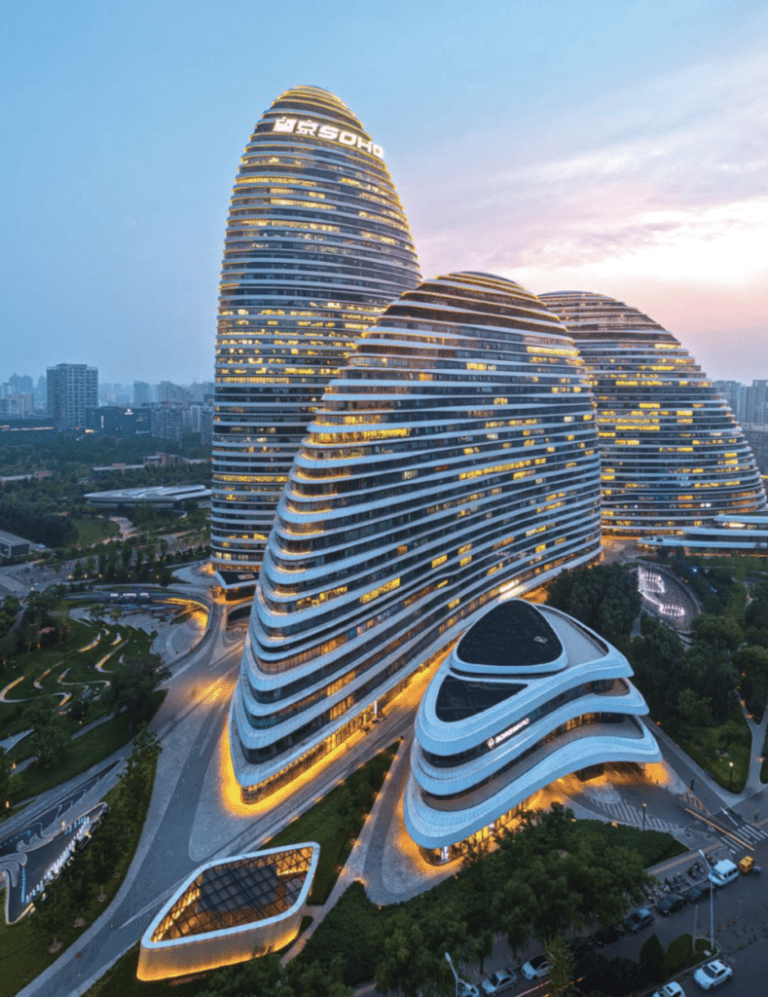 Futuristic curved skyscrapers illuminated at dusk in a modern cityscape.