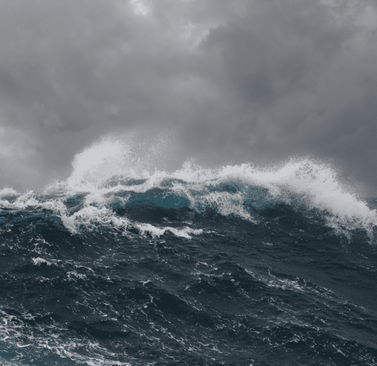 Powerful ocean waves crashing under a stormy sky.