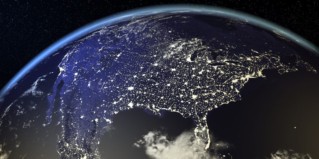 Nighttime satellite view of North America showing city lights.