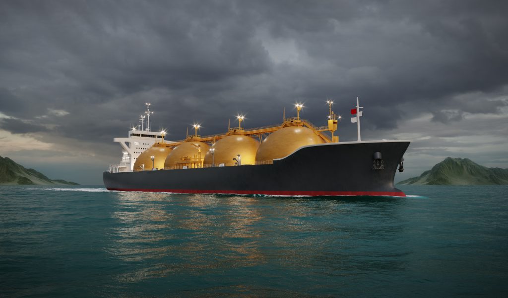 A large LNG tanker ship sailing under dark, cloudy skies.