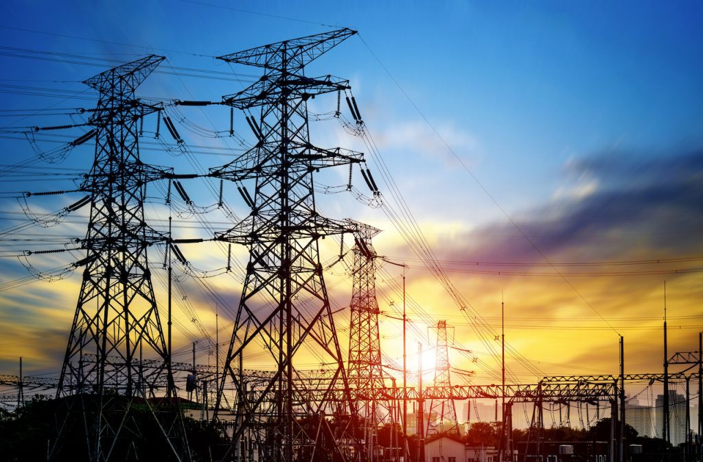 Electric power lines and towers at sunset.