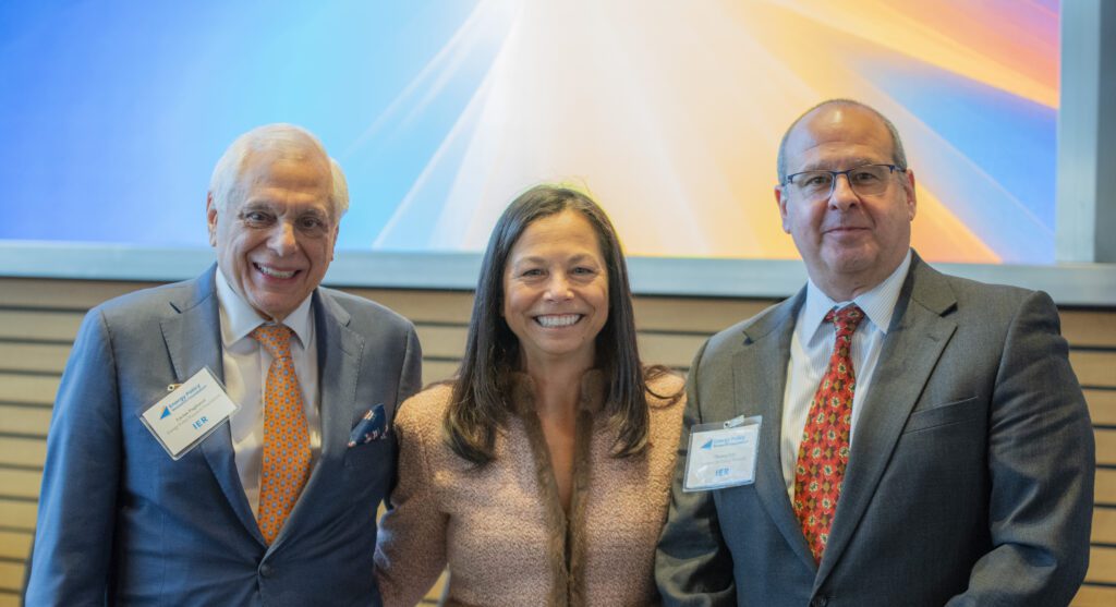 Three smiling professionals posing at conference