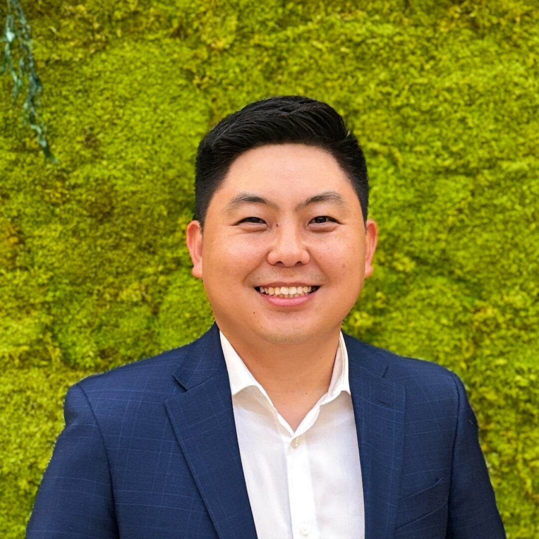 Smiling man in suit against green wall